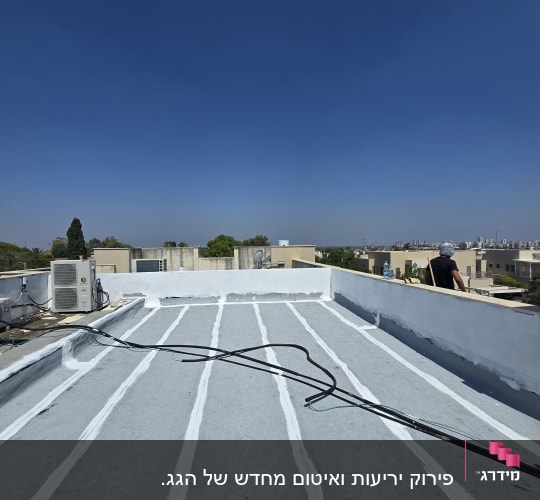 גג עם איטום לבן וכבלים שחורים